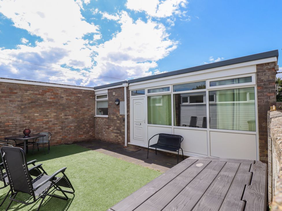 A garden with a table and chairs at Seaside Retreat Chapel Point near Chapel St Leonards