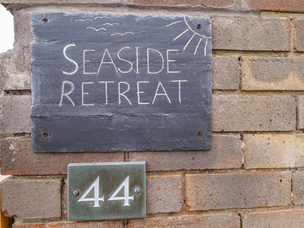 A sign for Seaside Retreat and number 44 at Seaside Retreat in Chapel Point near Chapel St Leonards