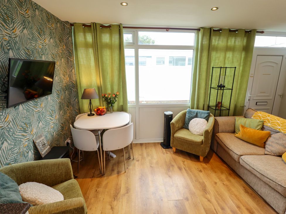 A living room with a sofa, table and chairs at Seaside Retreat near Chapel Point near Chapel St Leonards