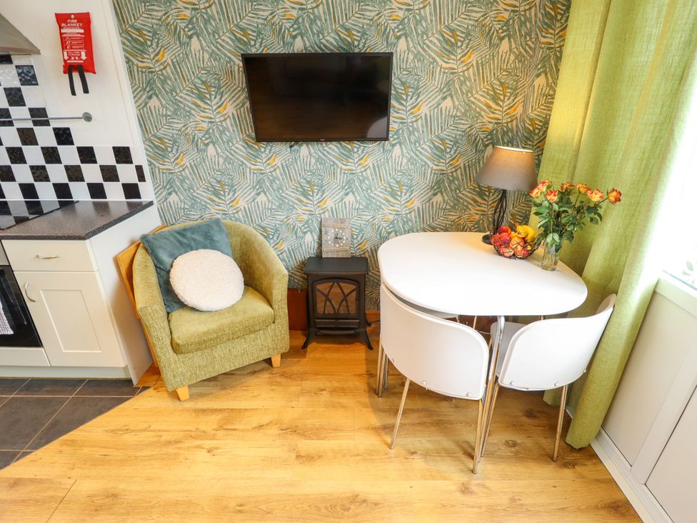 A kitchen with an armchair and a small table at Seaside Retreat near Chapel Point near Chapel St Leonards