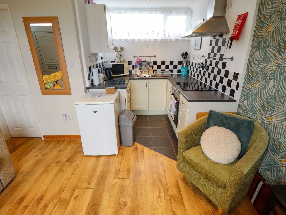 A kitchen with appliances and seating at Seaside Retreat near Chapel Point near Chapel St Leonards