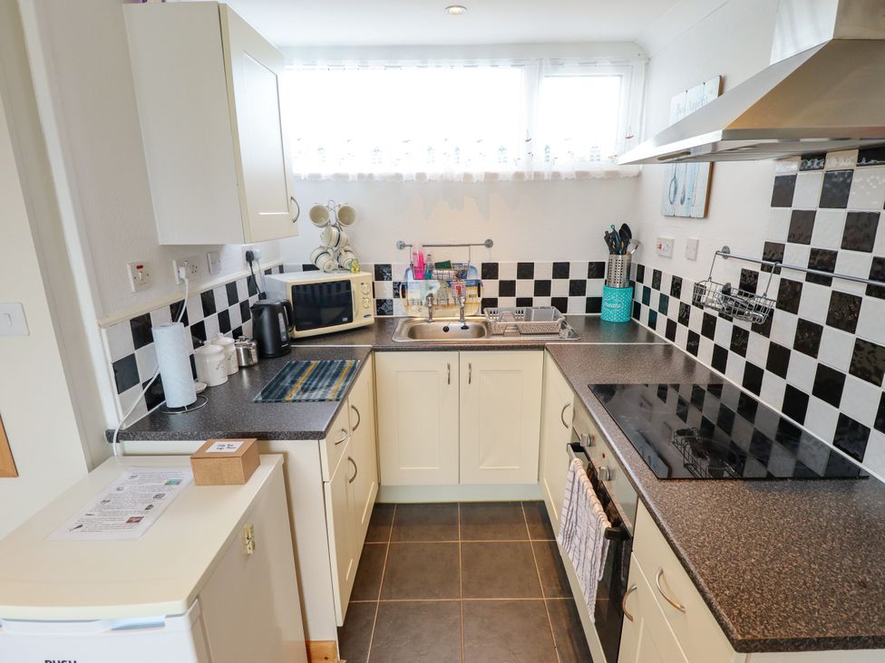 A kitchen with sink and microwave at Seaside Retreat Chapel Point near Chapel St Leonards