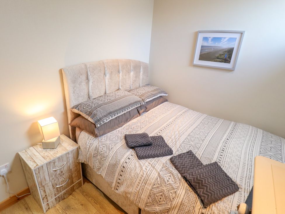 A bedroom with a bed and bedside table at Seaside Retreat in Chapel Point near Chapel St Leonards
