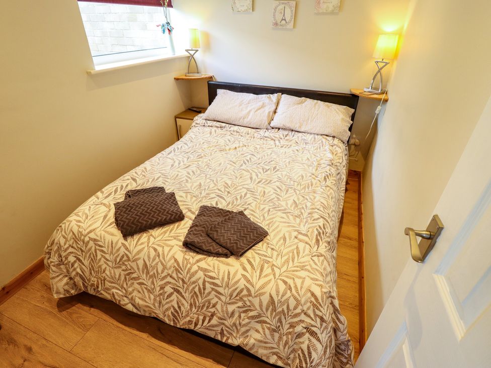 A bedroom with a bed and bedside table at Seaside Retreat in Chapel Point near Chapel St Leonards