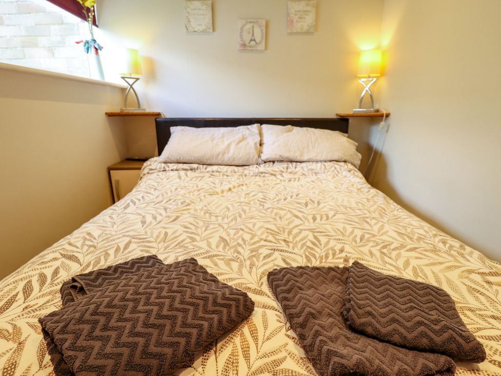 A bedroom with a bed and towels at Seaside Retreat Chapel Point near Chapel St Leonards