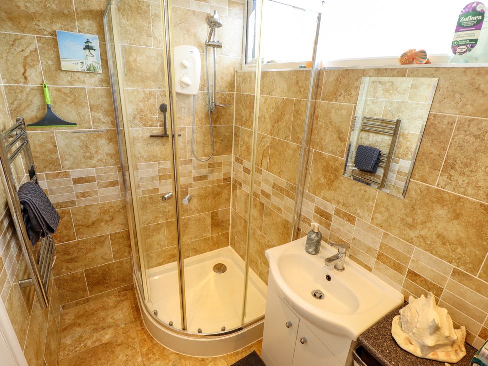 A bathroom with a shower and sink at Seaside Retreat Chapel Point near Chapel St Leonards