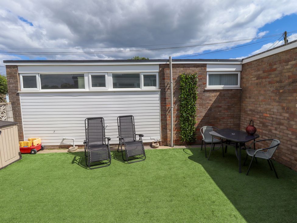 A garden with chairs and a table at Seaside Retreat in Chapel Point near Chapel St Leonards