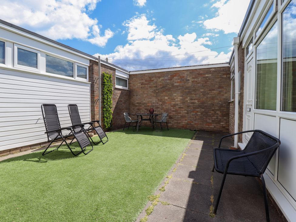 A garden with chairs and a table at Seaside Retreat Chapel Point near Chapel St Leonards