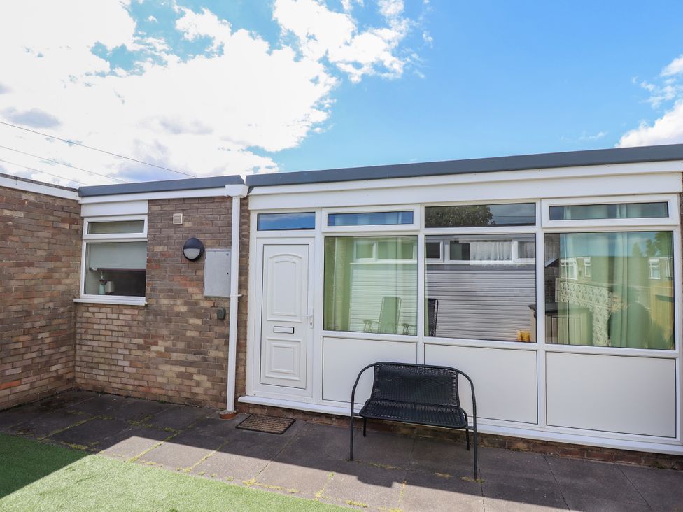 An outdoor area with a sliding door and bench at Seaside Retreat in Chapel Point near Chapel St Leonards