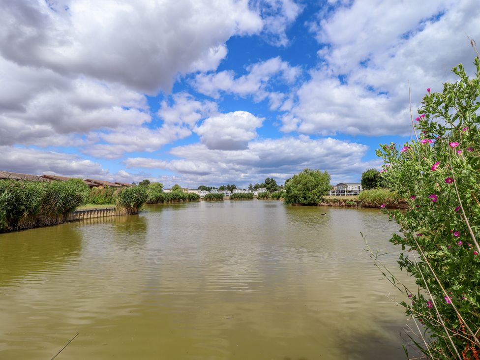 A view of a lake with cloudy sky and greenery at Seaside Retreat Chapel Point near Chapel St Leonards