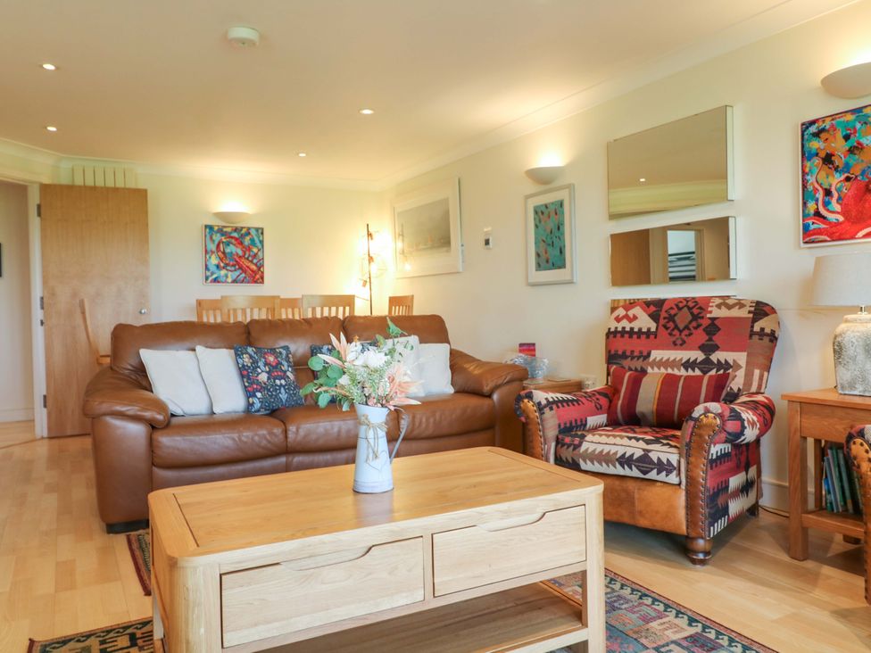 A living room with a sofa and armchair at 5 Thurlestone Beach in Thurlestone