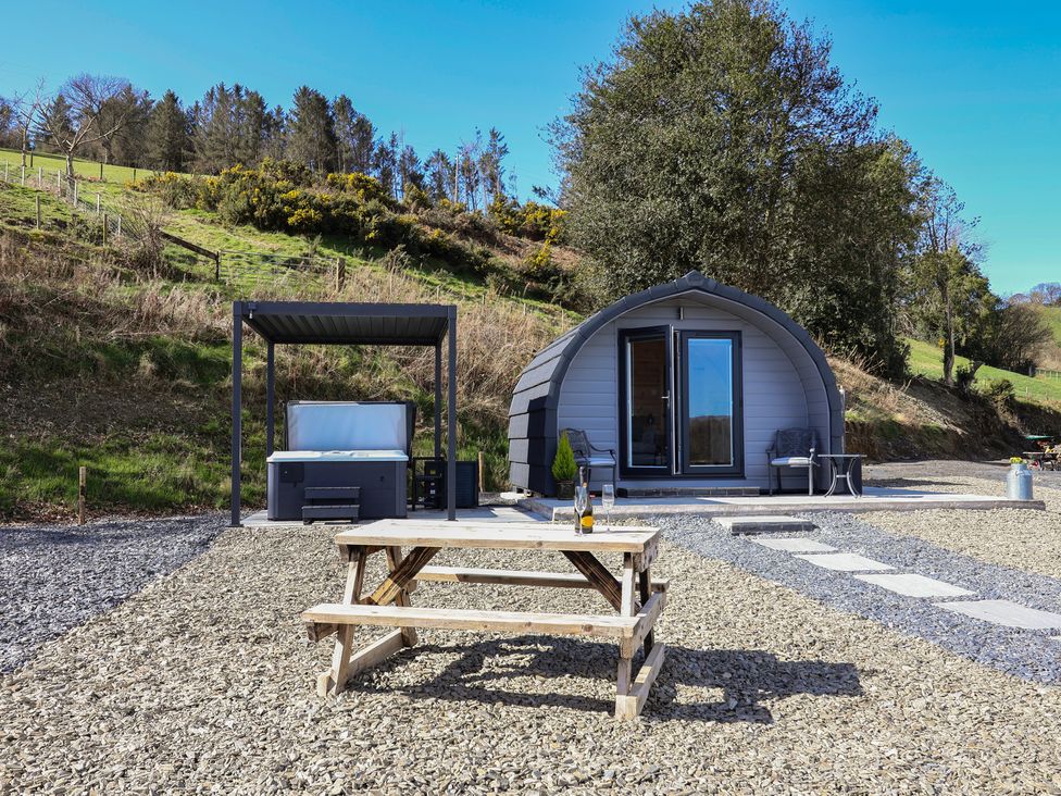 An outdoor area with a glamping pod and hot tub at Lili Wen Fach in Ruthin