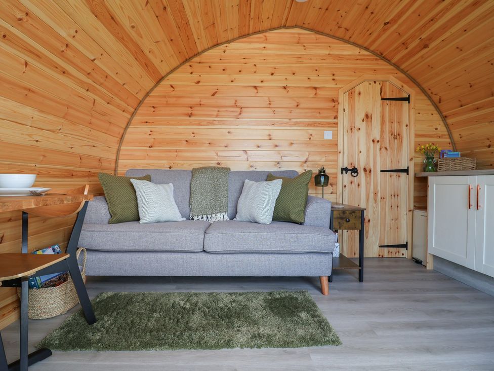 A snug with a sofa and table at Lili Wen Fach in Ruthin