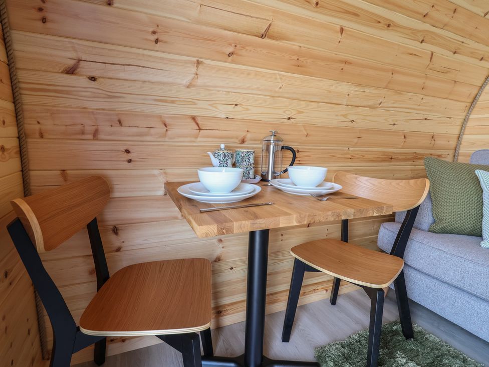 A dining area with a table and chairs at Lili Wen Fach in Ruthin