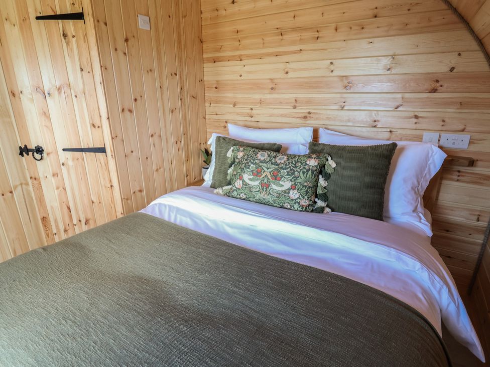 A bedroom with a wooden wall and a bed at Lili Wen Fach in Ruthin