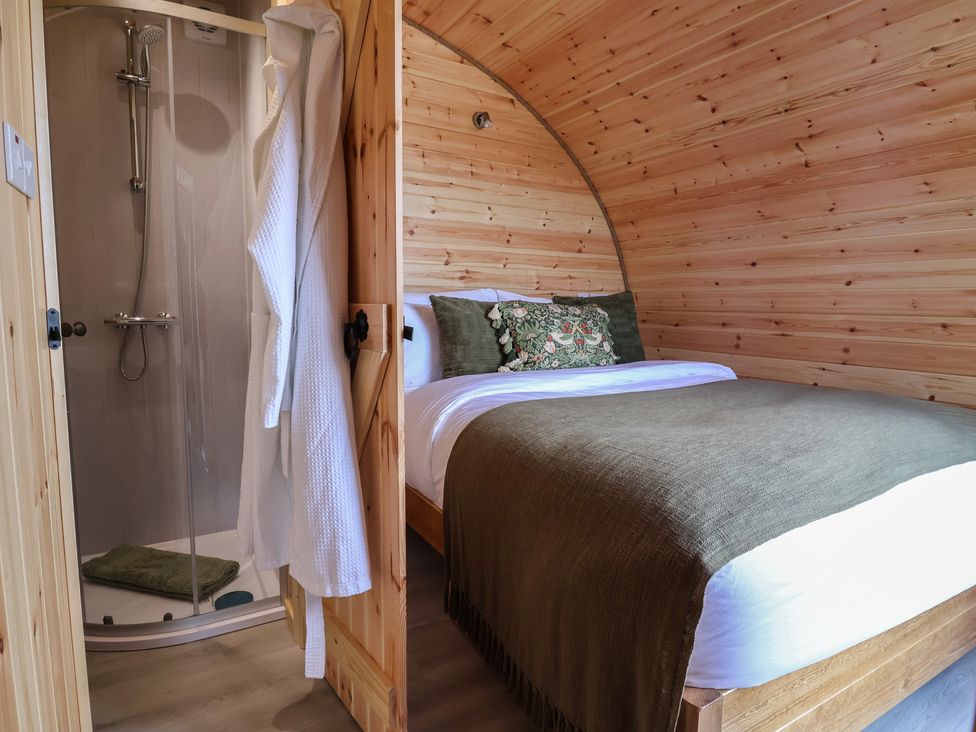 A bedroom with a bed and shower at Lili Wen Fach Ruthin