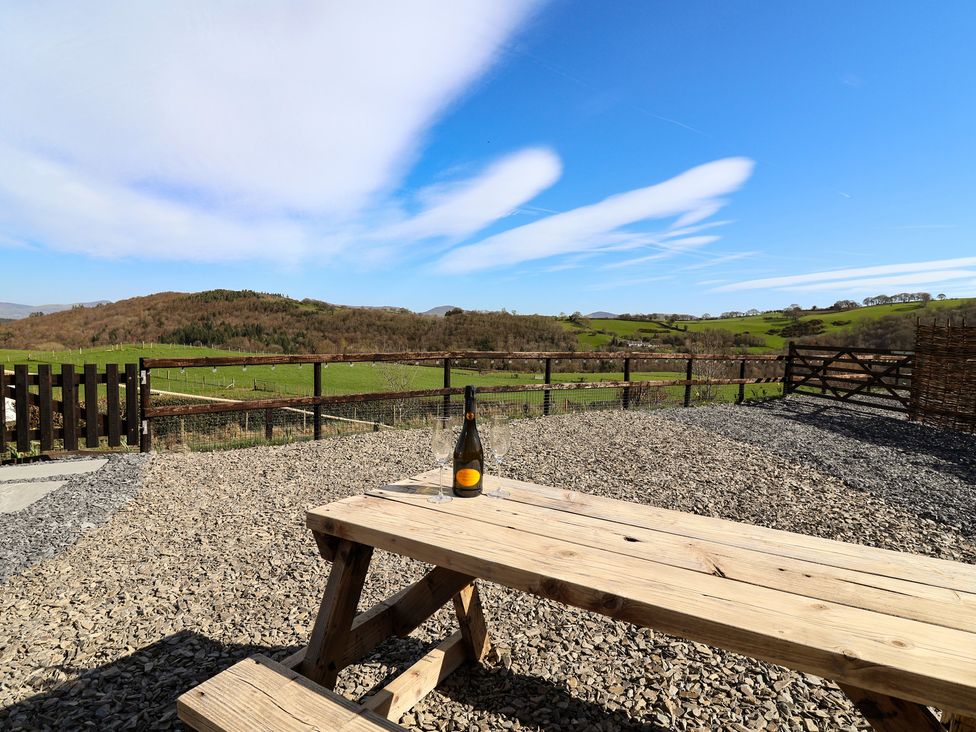 An outdoor area with a table and a bottle in Lili Wen Fach in Ruthin
