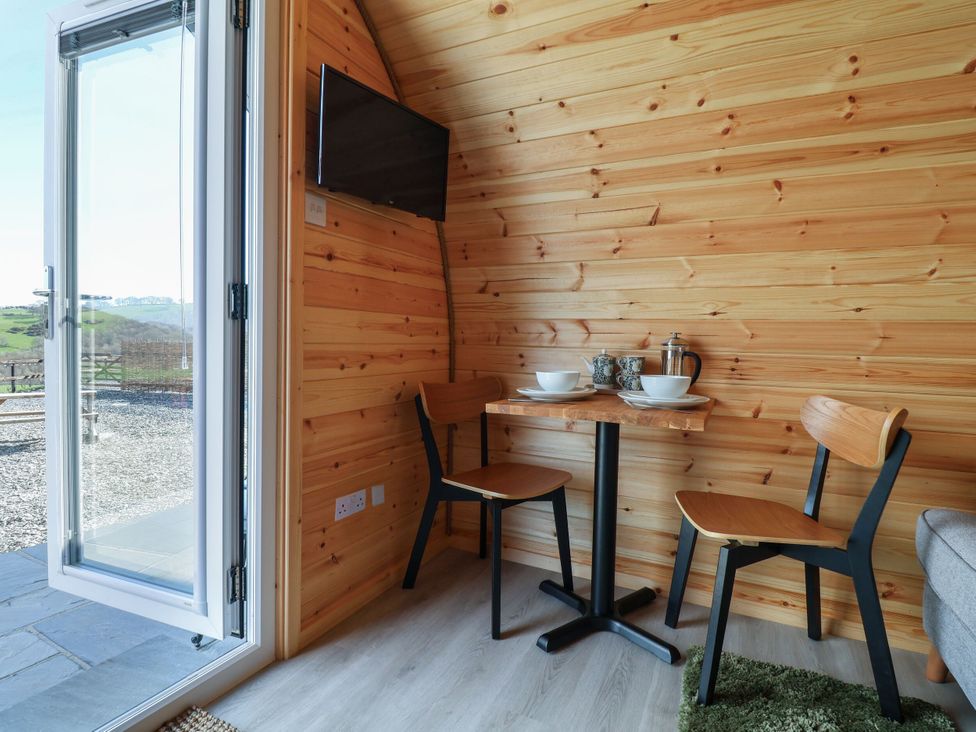 A dining area with a table and chairs at Lili Wen Fach near Ruthin