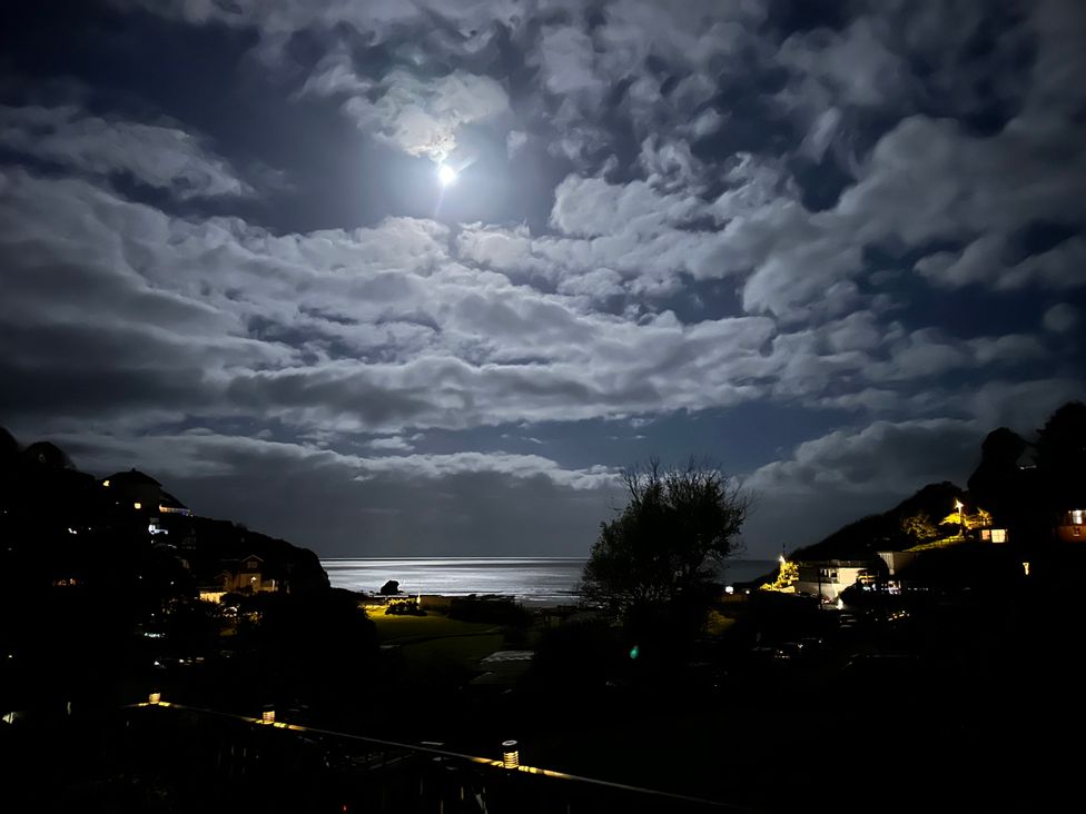 A night view of the ocean with moonlight and clouds at Shells Cottage in Looe