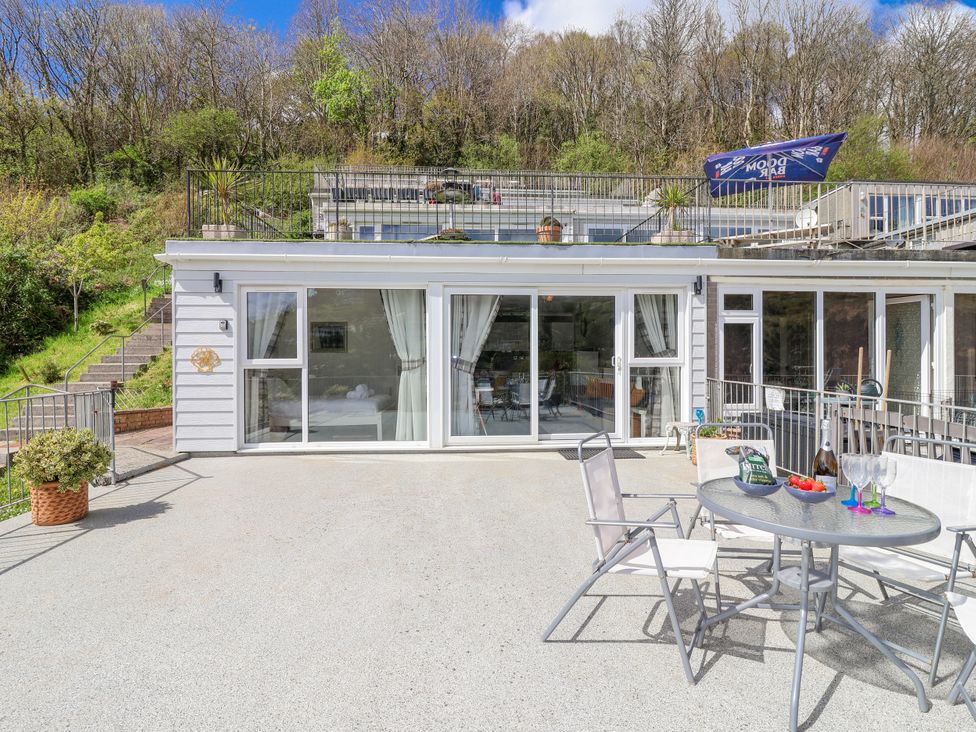 An outdoor dining area with a table and chairs at Shells Cottage in Looe