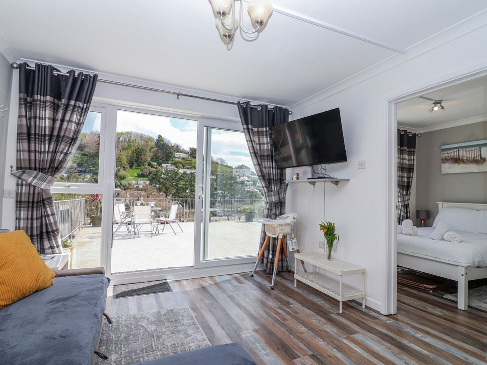 A living room with a television and a sofa at Shells Cottage in Looe