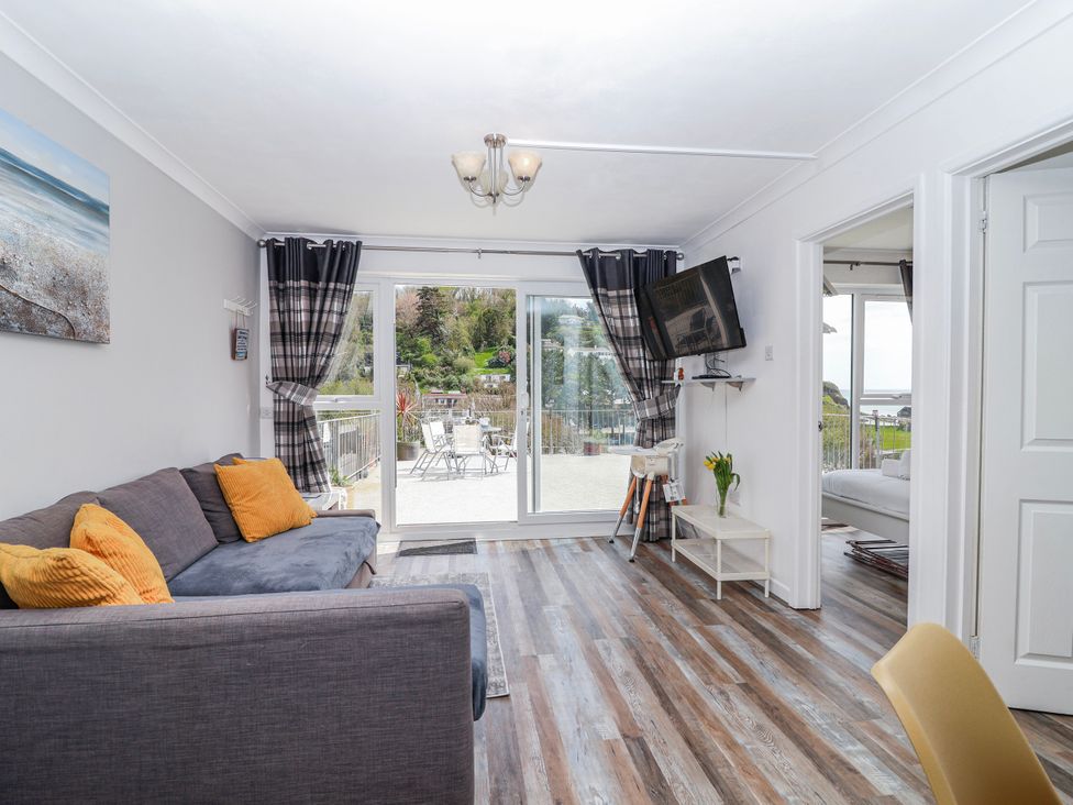 A living room with a sofa and television at Shells Cottage in Looe