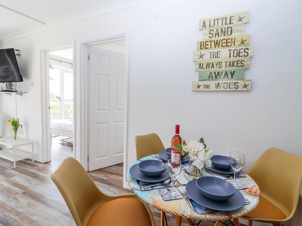 A dining room with a table set for a meal at Shells Cottage in Looe