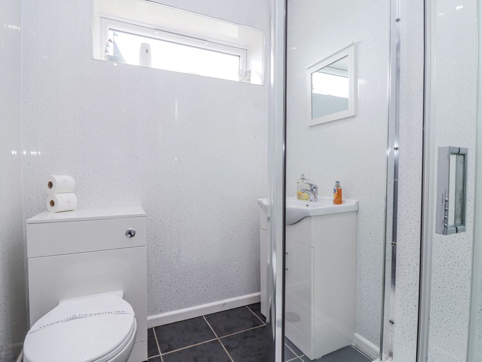 A bathroom with a toilet and sink at Shells Cottage in Looe