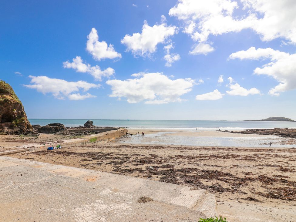 A beach scene with a view of the sea and a pier at Shells Cottage in Looe