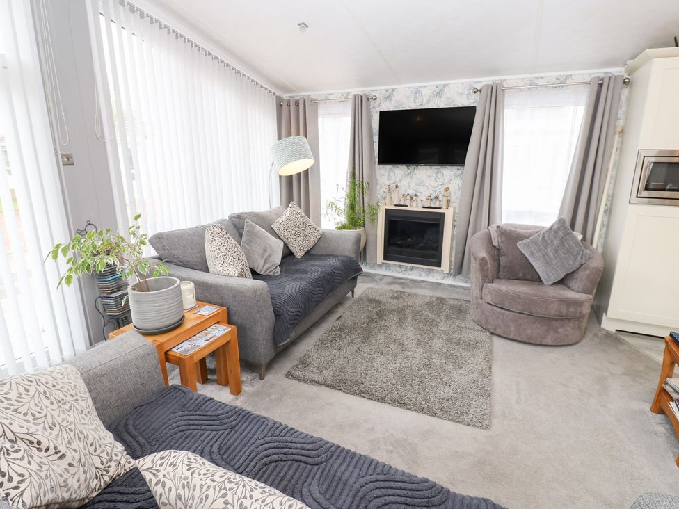 A living room with a sofa and armchair at A and C Lodge-Plot 21 Armathwaite