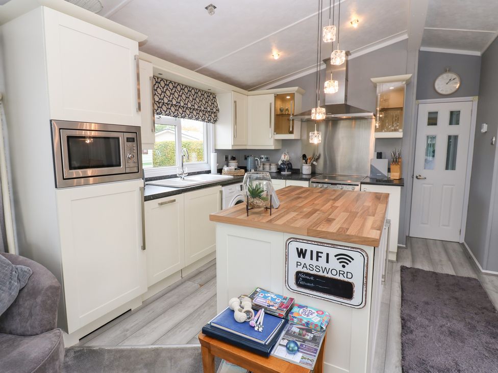 A kitchen with modern appliances and a wooden countertop at A and C Lodge-Plot 21 Armathwaite