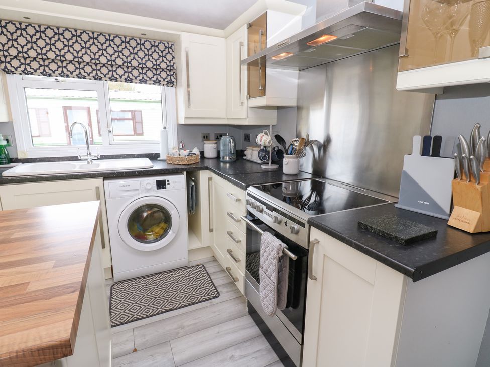 A kitchen with an oven and washing machine at A and C Lodge-Plot 21 Armathwaite