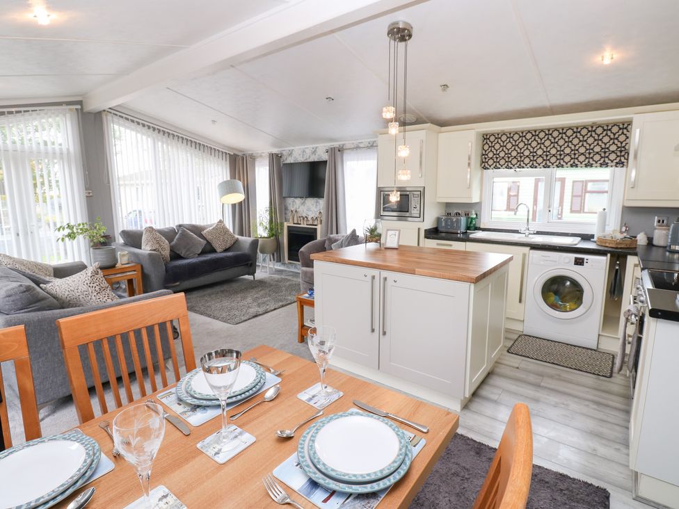 An open plan living area with kitchen and dining table at A and C Lodge-Plot 21 Armathwaite