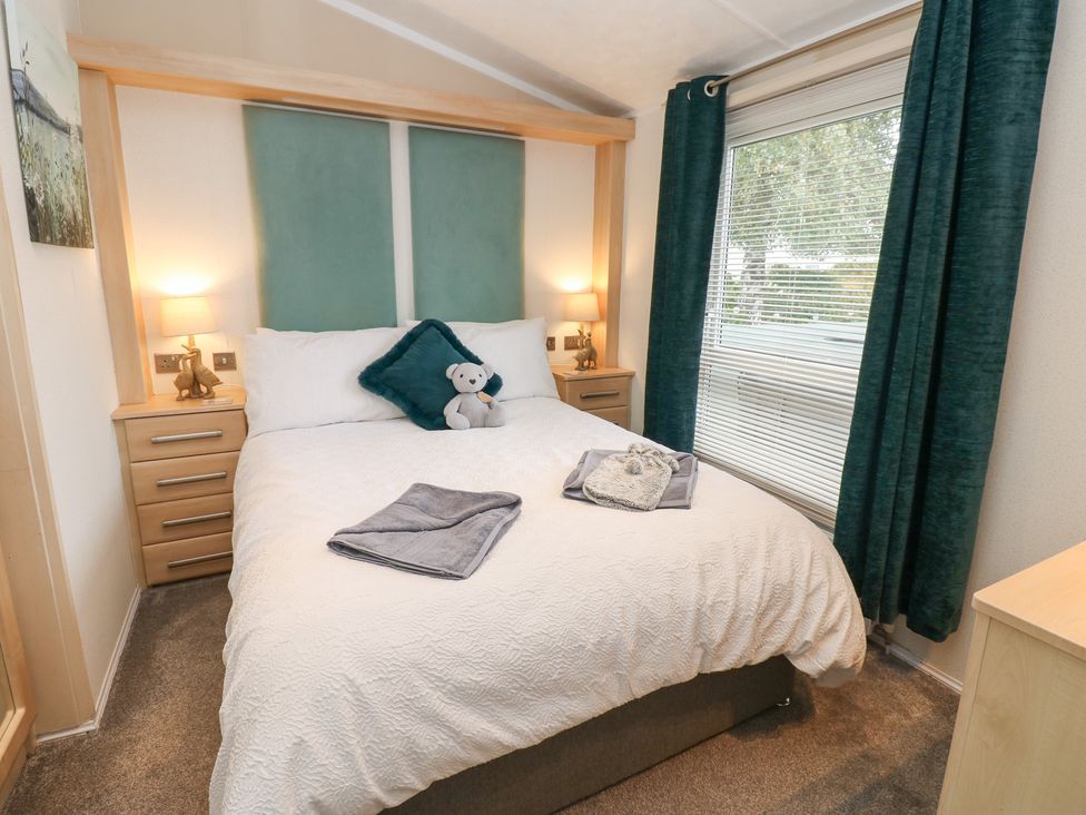 A bedroom with a bed and bedside tables at A and C Lodge-Plot 21 Armathwaite