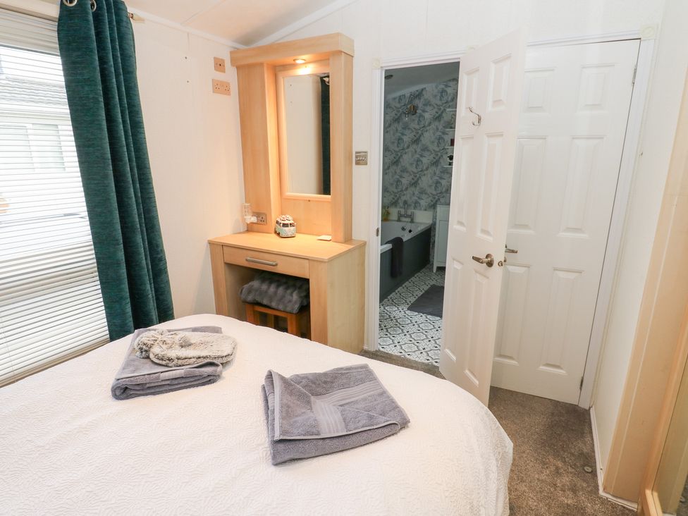 A bedroom with a bed and dresser at A and C Lodge-Plot 21 Armathwaite