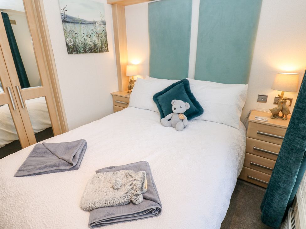 A bedroom with a bed and bedside tables at A and C Lodge-Plot 21 Armathwaite