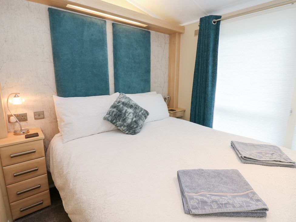 A bedroom with a bed and bedside table at A and C Lodge-Plot 21 Armathwaite