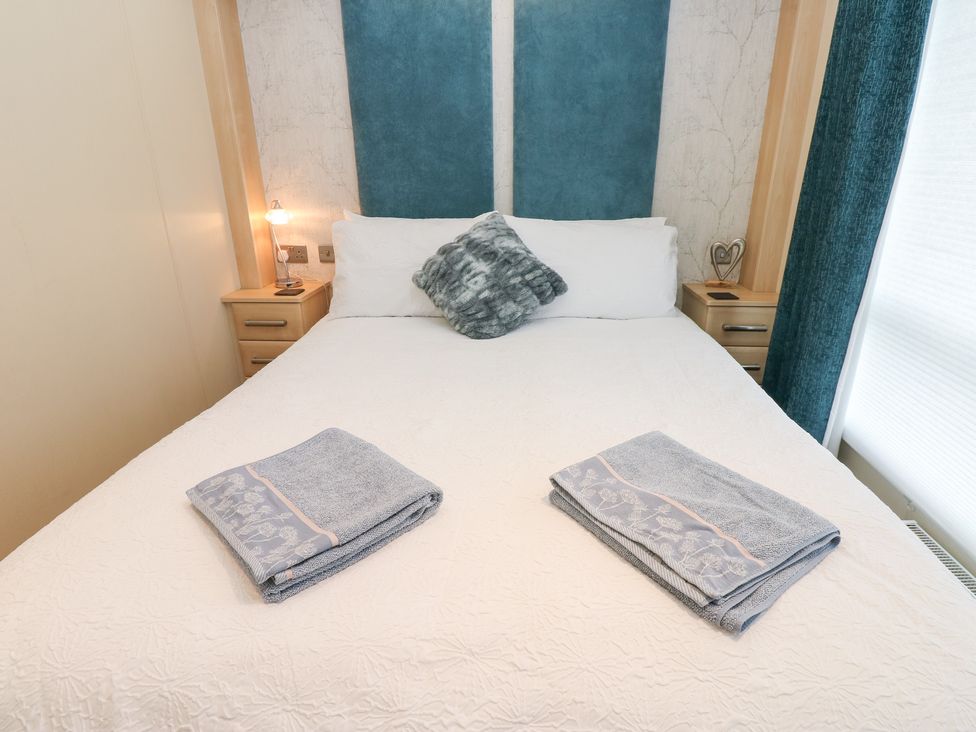 A bedroom with a bed and towels folded at A and C Lodge-Plot 21 Armathwaite