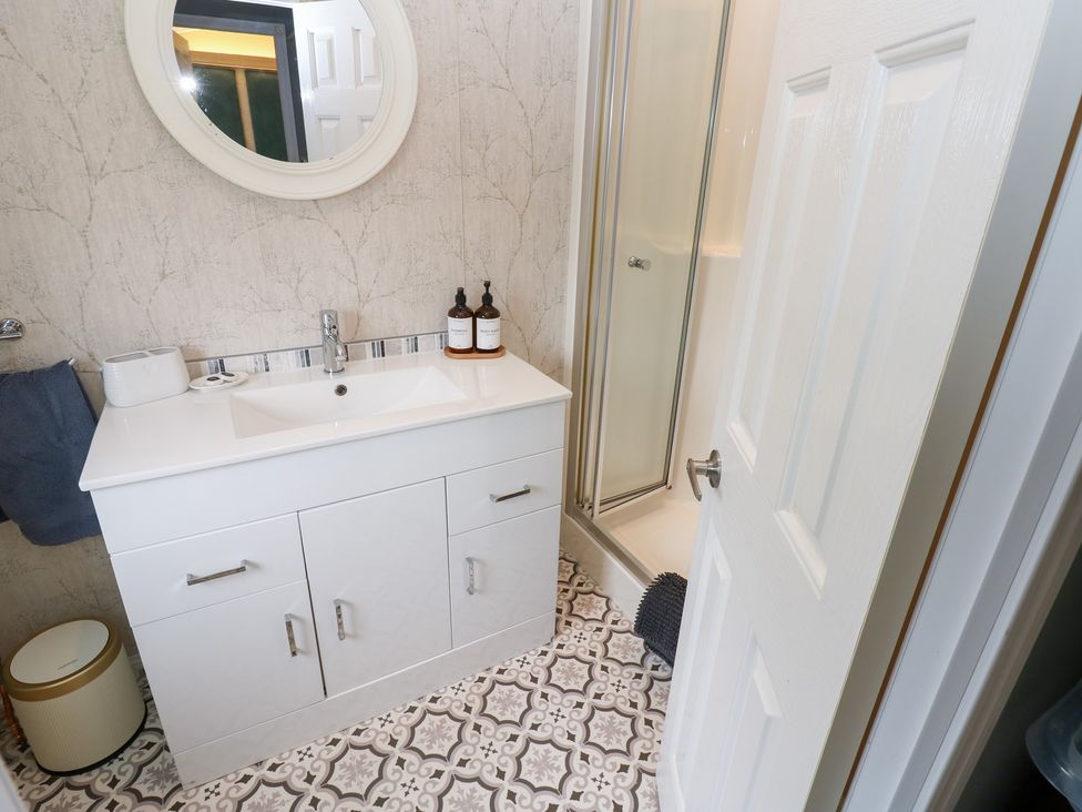 A bathroom with a sink, shower, and mirror at A and C Lodge-Plot 21 Armathwaite
