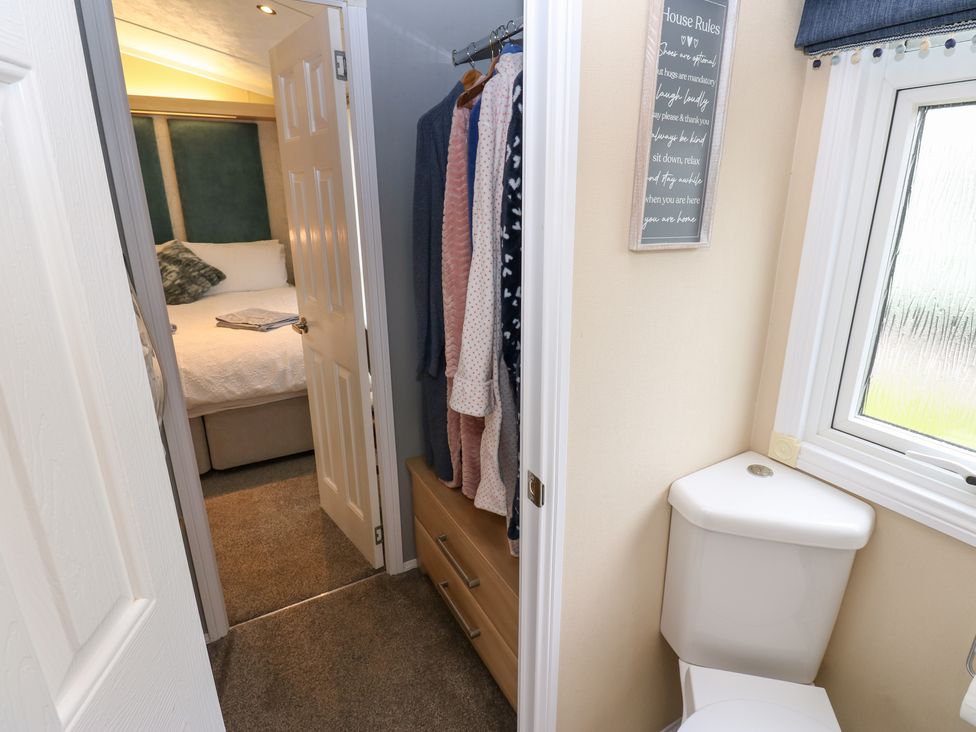 A bathroom with a toilet and a view of a bedroom at A and C Lodge-Plot 21 Armathwaite