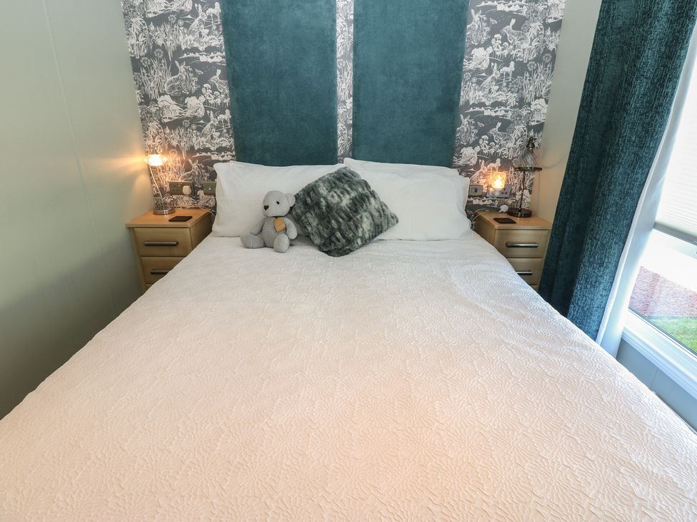 A bedroom with a bed and nightstands at A and C Lodge-Plot 21 Armathwaite