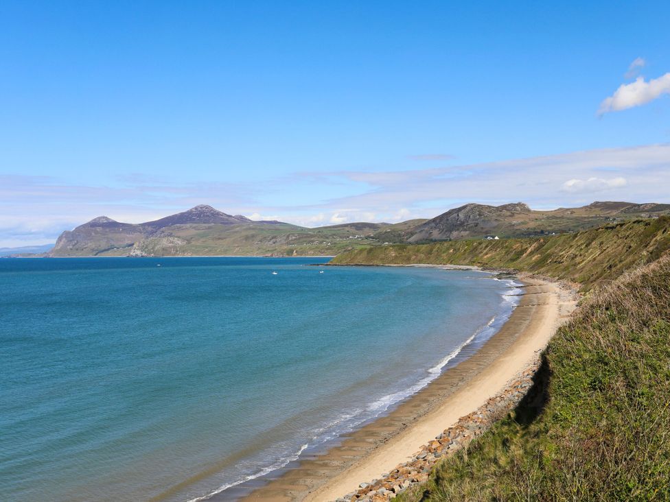 A beach and coastline with mountains in the background at Seaviews in Nefyn