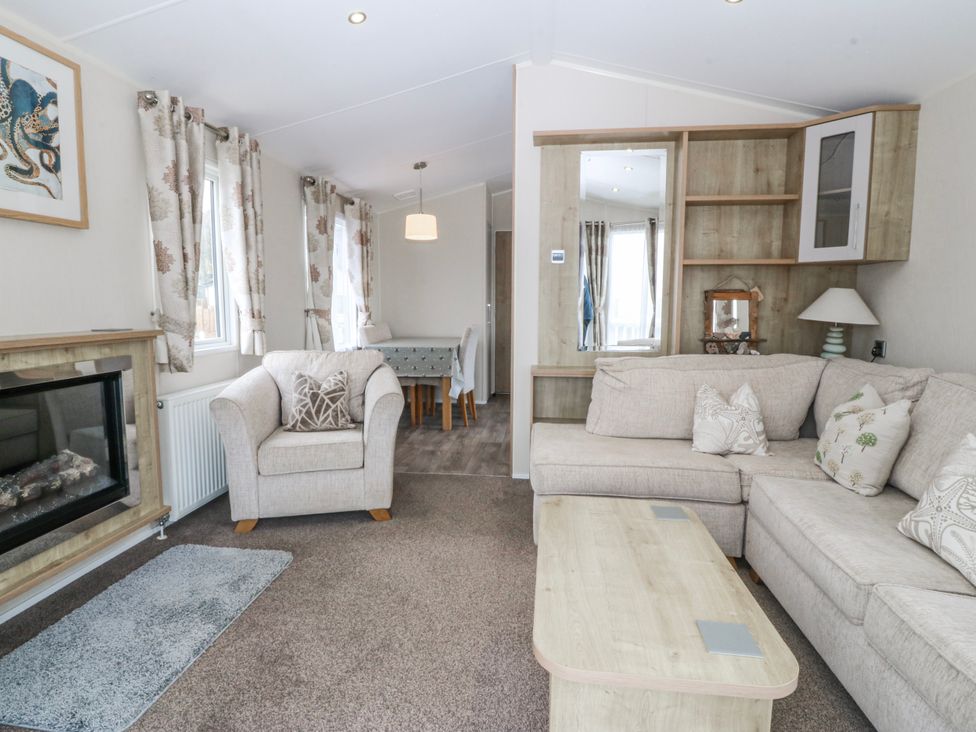 A living room with a sofa and armchair at Seaviews in Nefyn