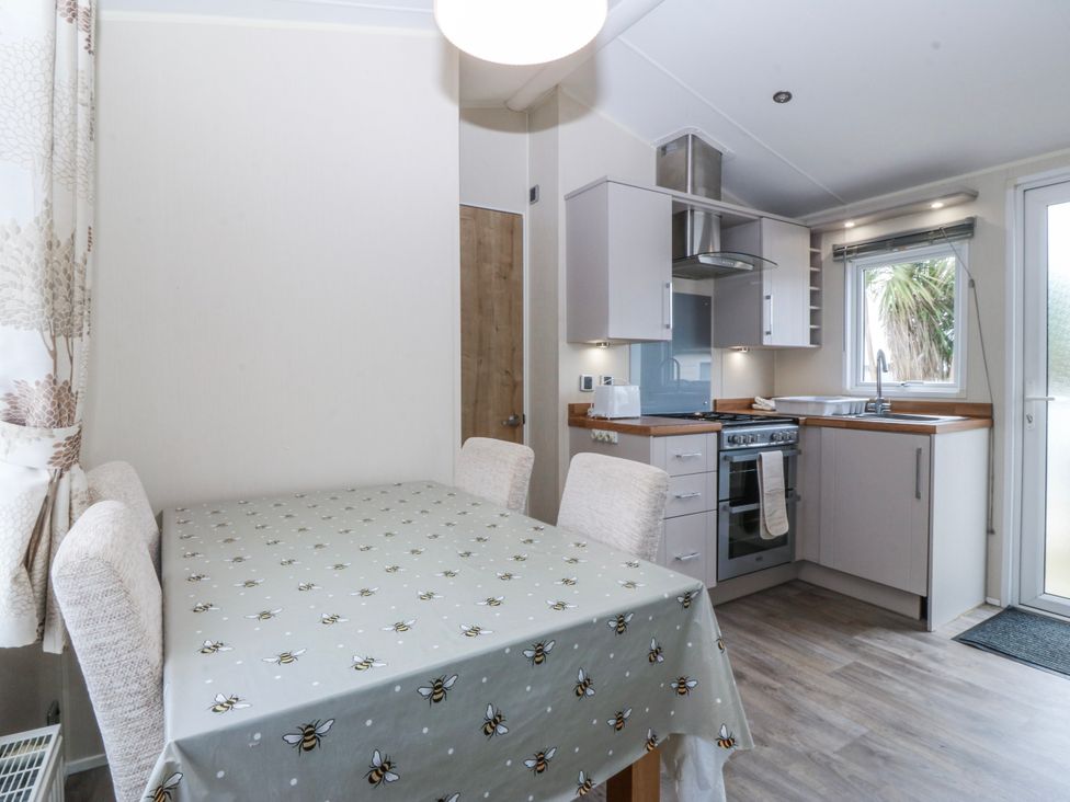 A kitchen with dining table and chairs at Seaviews in Nefyn