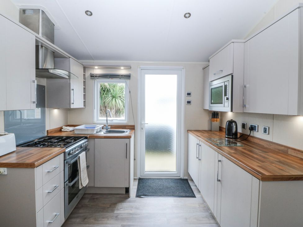 A kitchen with cabinets and appliances at Seaviews in Nefyn
