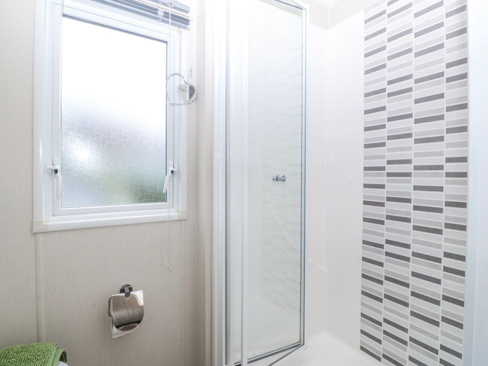 A bathroom with shower and window at Seaviews in Nefyn