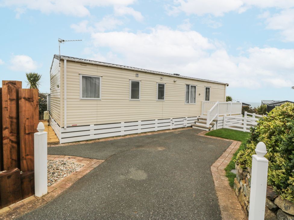 A caravan with steps and fence at Seaviews in Nefyn