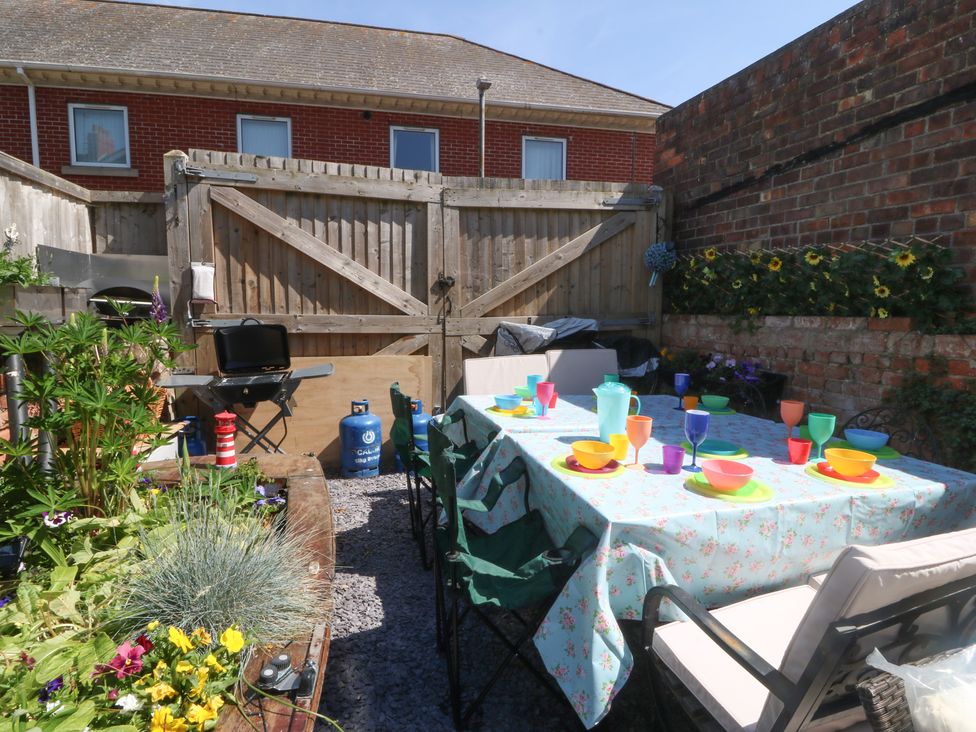 A garden with a table set for dining at Yr Angor (The Anchor) Llandudno Junction
