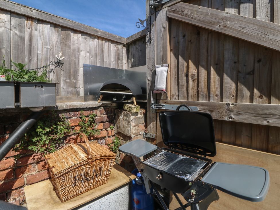 An outdoor area with a grill, a basket, and planters at Yr Angor (The Anchor) in Llandudno Junction