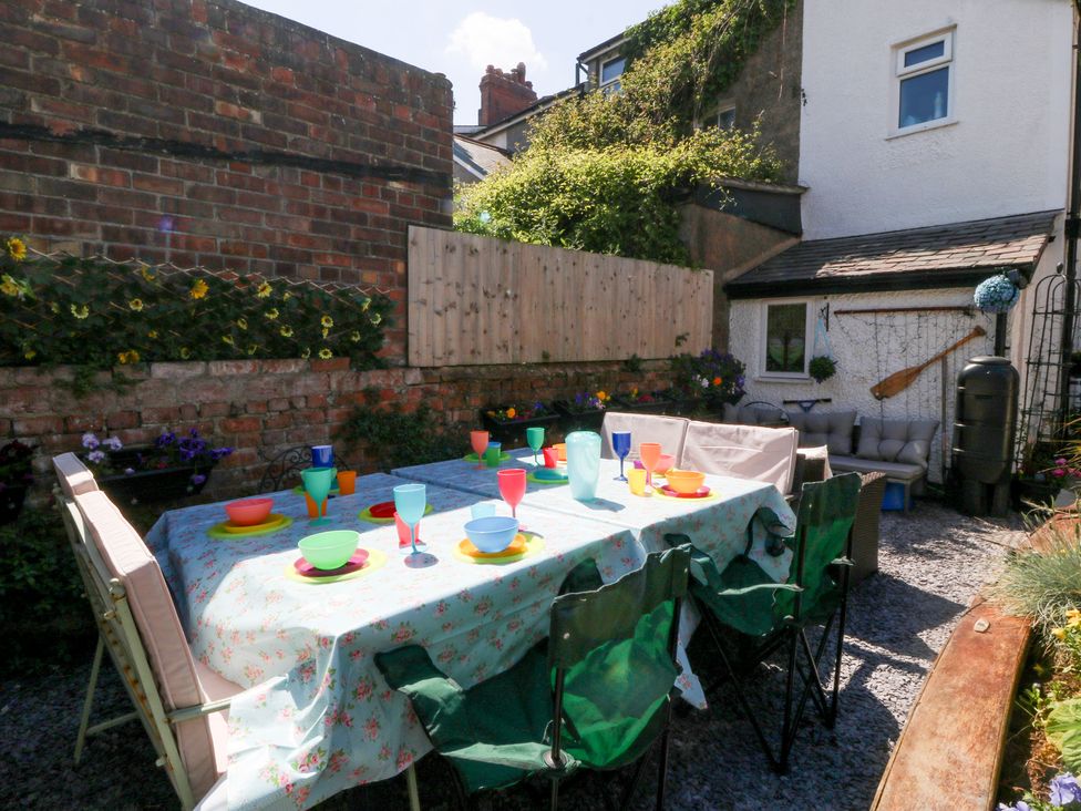 A garden with a table set for dining at Yr Angor (The Anchor) Llandudno Junction